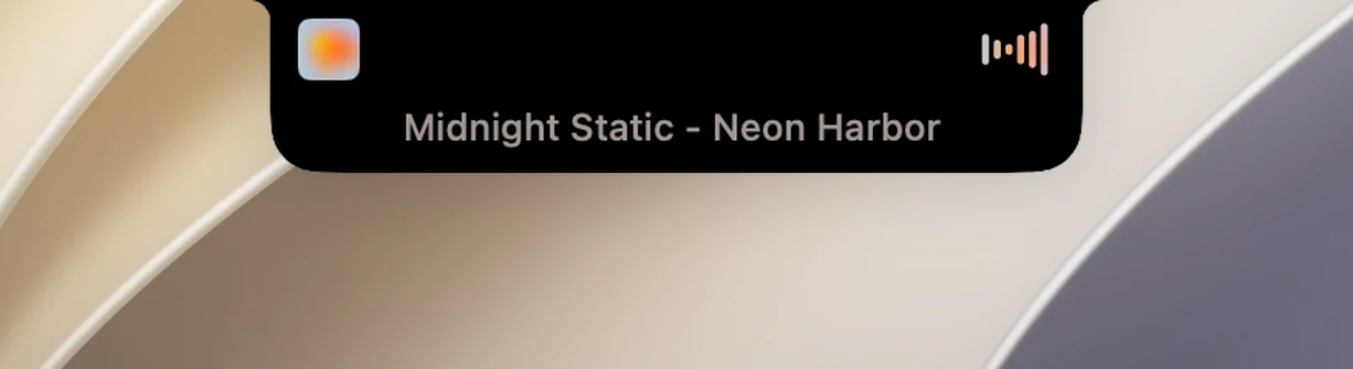 Die geschlossene Notch während der Wiedergabe: links das Albumcover, rechts ein Visualizer in den Farben des Albumcovers und darunter eine durchlaufende Zeile mit dem Songtitel